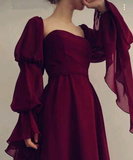 A wine-red gown with trailing sleeves