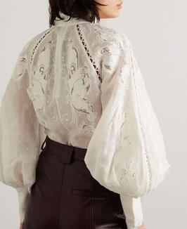 A silk blouse with intricate lace panels; available in various colors